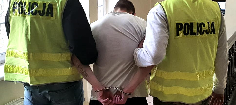 dwóch policjantów i zatrzymany w kajdankach