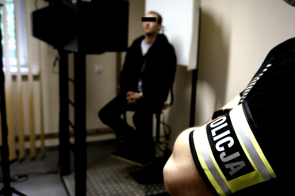 w mopieszczeniu technika kryminalistyki, na pierwszym planie policjant w tle zatrzymany