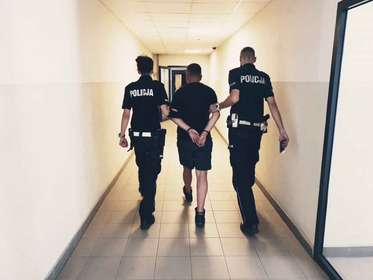policjanci z drogówki prowadzą zatrzymanego