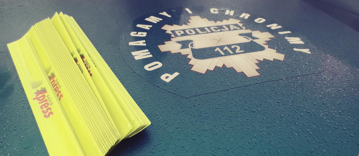 zdjęcie z akcji świeć przykładem - noś odblaski - odblaski z napisem radio express leżą na masce policyjnego radiowozu - logo policji