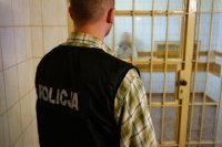Policjant pilnujący zatrzymanego