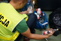 Policjant pokazujący zarekwirowany lewy alkohol