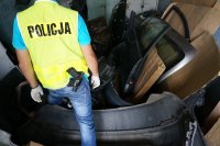 Policjant w jednym z magazynów z częściami pochodzącymi ze skradzionych samochodów