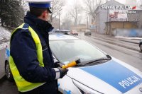 Wizerunek Policjanta z urządzeniem do pomiaru stanu trzeźwości kierujących
