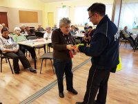 Policjant daje starszej kobiecie odblaskową opaskę