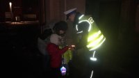 Policjant przekazuje odblaskową opaskę