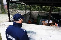 Dzielnicowy st.asp. Piotr Nowak przed śmietnikową wiatą