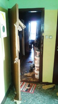 Drzwi do mieszkania i skradzione pojemniki z tynkiem