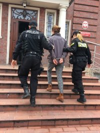 Policjanci prowadzą zatrzymaną matkę