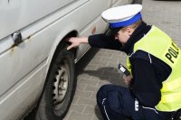 Policjant sprawdza stan ogumienia busa