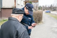 Pokazuje starszemu mężczyźnie aplikację "Moja Komenda"