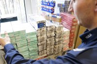 Policjant z zabezpieczonymi papierosami