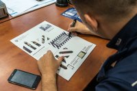 Dzielnicowy wypełniający dane na plakacie