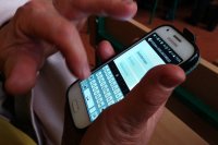 Telefon z aplikacją Moja Komenda w rękach uczestnika spotkania