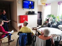 Seniorzy oglądają film profilaktyczny o oszustwach na wnuczka