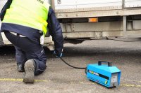 Policjant dokonujący pomiaru emisji spalin - foto: policja.pl