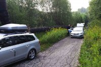 Passat i radiowóz na drodze w środku lasu