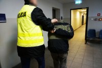 Policjant prowadzi zatrzymanego