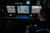 Policjant obserwujący rejon skrzyżowania za pomocą systemu kamer