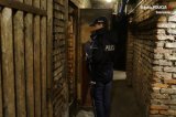 Policjant przy otwartych drzwiach piwnicy