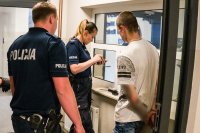 Kierowca i jego pasażer w asyście policjantów