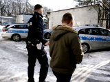 Policjant prowadzi zatrzymanego nietrzeźwego kierowcę