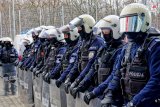 Zdjęcie - policjanci prewencji stojący w szyku z tarczami do ochrony