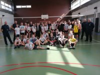 Zdjęcie zbiorowe uczestników turnieju - hala sportowa dzieci stojące i siedzące po obu bokach policjanci w mundurach.