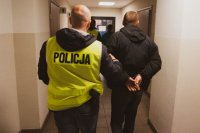 zdjęcie -  policjanci prowadzą zatrzymanych korytarzem