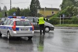 zdjęcie archiwalne przedstawia policjanta drogówki kierującego ruchem w trakcie intensywnych opadów deszczu