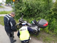 zdjęcie przedstawia policjanta drogówki i motocyklisty przy skuterze
