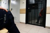 zdjęcie poglądowe - cela z zatrzymanym, policjant siedzący przed - foto z archiwum