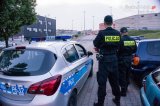 zdjęcie poglądowe przedstawia dwóch policjantów stojących obok radiowozu oznakowanego