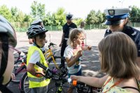 zdjęcie przedstawia - uczestników egzaminu i dziewczynkę która włączyła otrzymaną lamkę