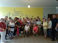 zdjęcie grupowe w pomieszczeniu przedstawia osoby starsze i policjanta w trakcie spotkania profilaktycznego
