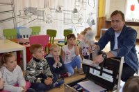 zdjęcie przedstawia dzieci i technika kryminalistyki w trakcie zajęć z poszukiwania śladów