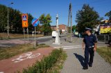 zdjęcie poglądowe - policjant idący chodnikiem przy przejściu dla pieszych w rejonie szkoły
