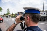 policjant drogówki obserwuje drogę przez lornetkę