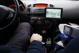 zdjęcie - wnętrze policyjnego radiowozu, widać kierowcę i pasażera z czapką policjanta drogówki