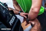 zdjęcie poglądowe - policjant zakłada zatrzymanemu kajdanki