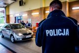 Stacja diagnostyczna, na pierwszym planie policjant w tle samochód skoda