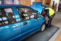 zdjęcie kolorowe - kontrola samochodu matiz policjant przy otwartej masce silnika