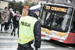 policjant drogówki w rejonie cmentarza, w tle autobus z numerem linii i napisem cmentarz