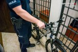 zdjęcie poglądowe - policjant z rowerem przy policyjnej celi