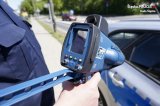 policjant trzymający w ręku laserowy miernik prędkości
