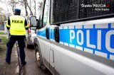 policjant przy radiowozie oznakowanym