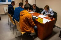 pomieszczenie, przy biurku siedzą osoby prowadzące rejestrację rezerwistów