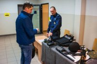 punkt wydawania wyposażenia i broni, policjant prezentuje rezerwiście wyposażenie na czas zagrożenia bezpieczeństwa państwa