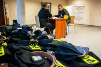 punkt wydawania umundurowania, pracownik magazynu zapoznaje rezerwistę z umundurowaniem