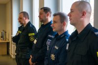policjanci stojący w rzędzie, obserwator i prowadzący szkolenie